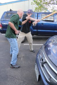 Image of a man with a bat attacking a man with a knife