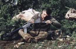 soldier using knife to clean gun