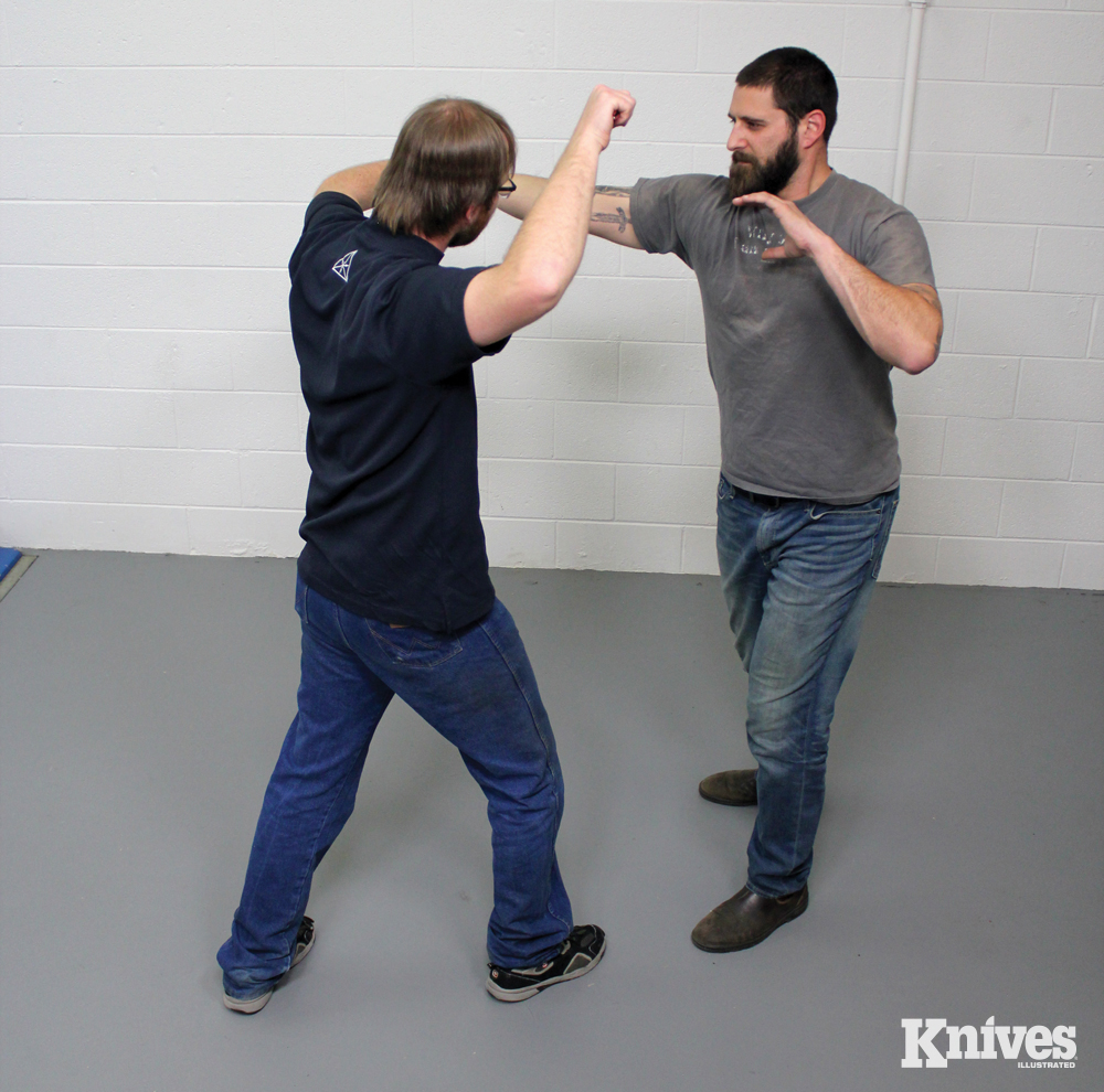 He follows by grabbing the attacker’s wrist and prepares for his next cut.