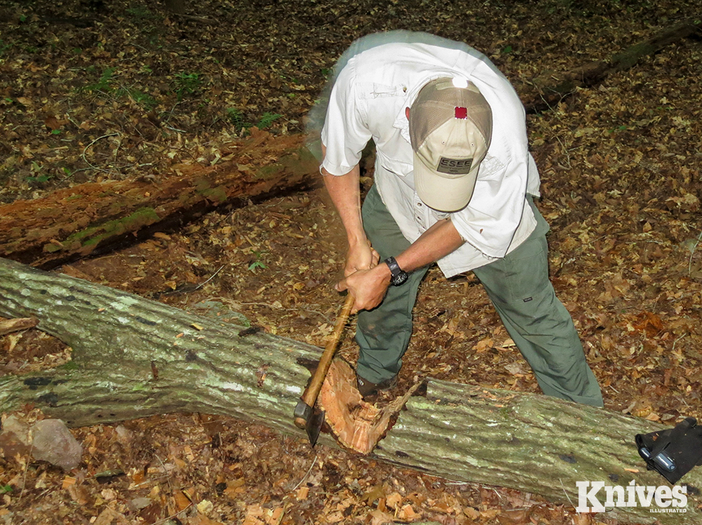 The user chops a “V” cut the width of the logs diameter, with a two-handed grip.