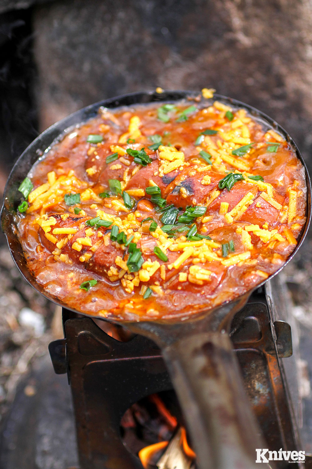 The open-faced chili cheese dog skillet with wild onions foraged by the author.