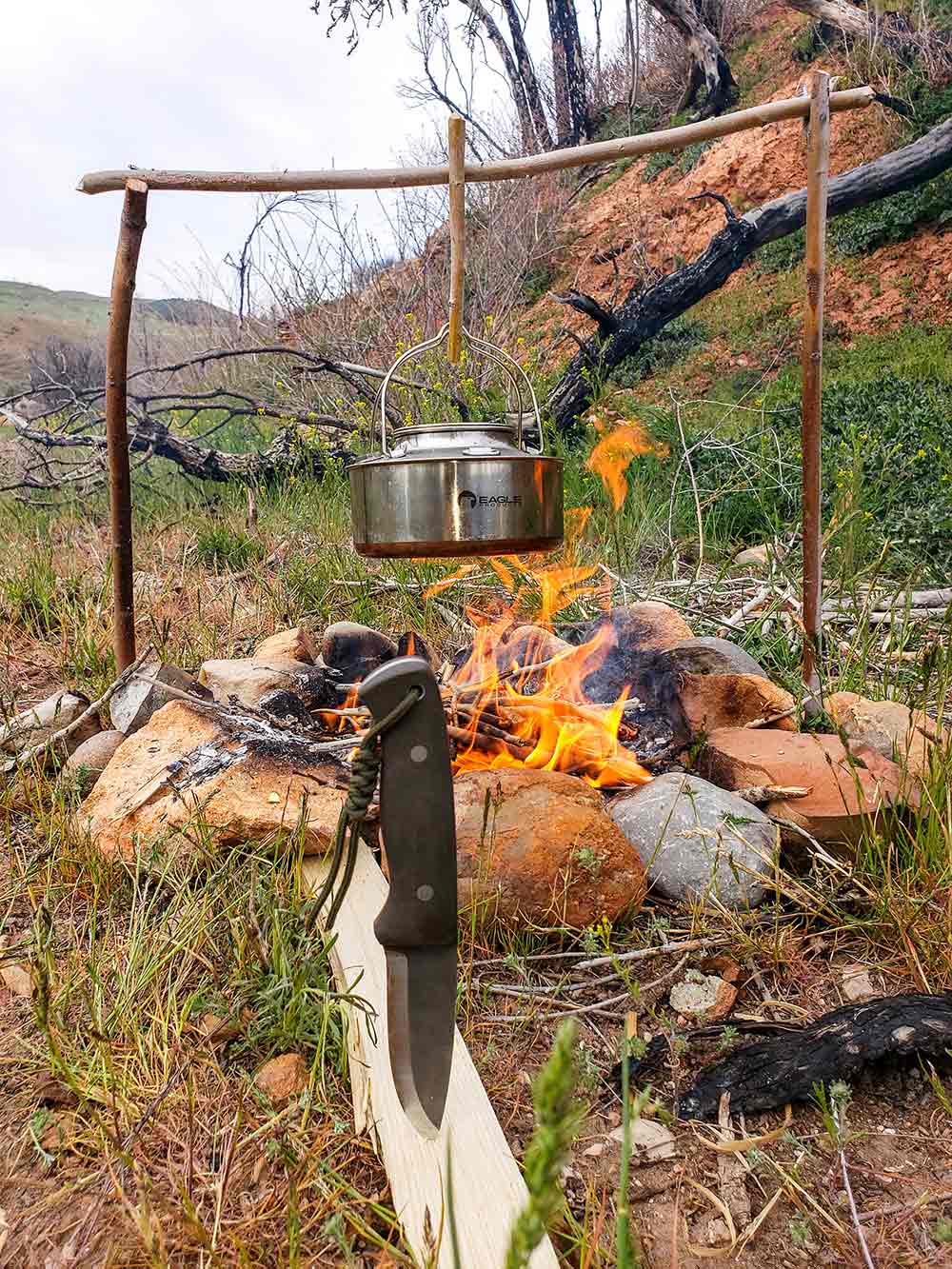 The author used the Orford Trapper to create a bushcraft cooking setup with “Y” branch uprights to hold his coffee pot in camp.