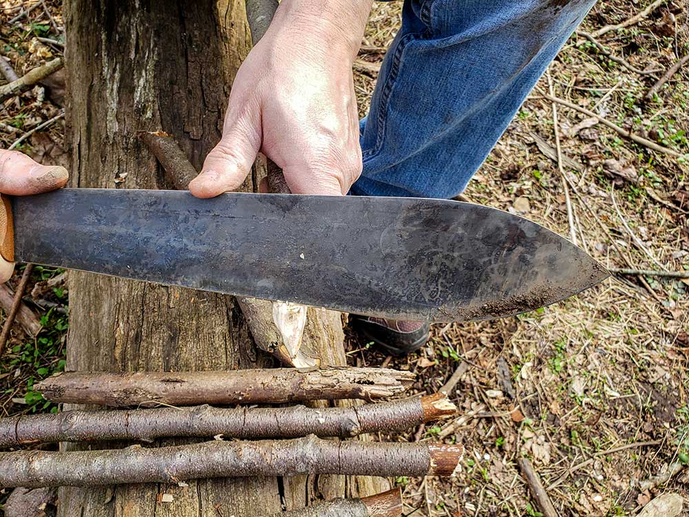 The author always carves a wooden stake shortly after arriving at camp.